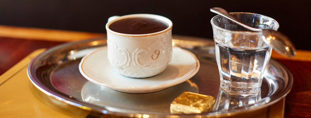 Coffees at Fischer's with small chocolate in ornate china cup